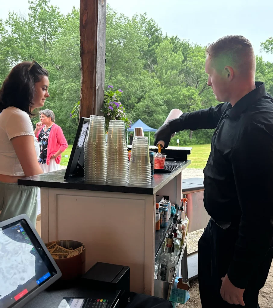 Professional mobile bar setup with bartender serving drinks